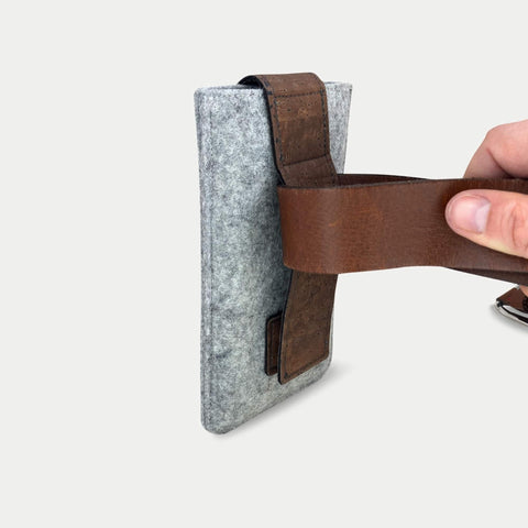 Handytasche aus Filz mit braunem Gürtelriemen für iPhone 16 Pro Max mit magnetischem Verschluss.